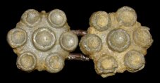 Cast pewter buttons with a copper alloy link. The motif of six circles around a center circle gives the appearance of being a setting for jewels, though it clearly was not designed to have any. 